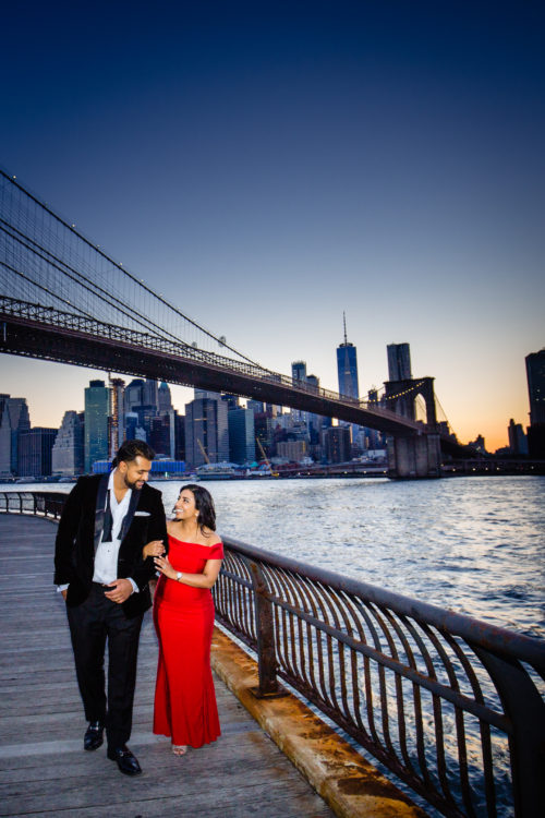 Destination Engagement photo session of couple walking in Brooklyn Bridge Park 